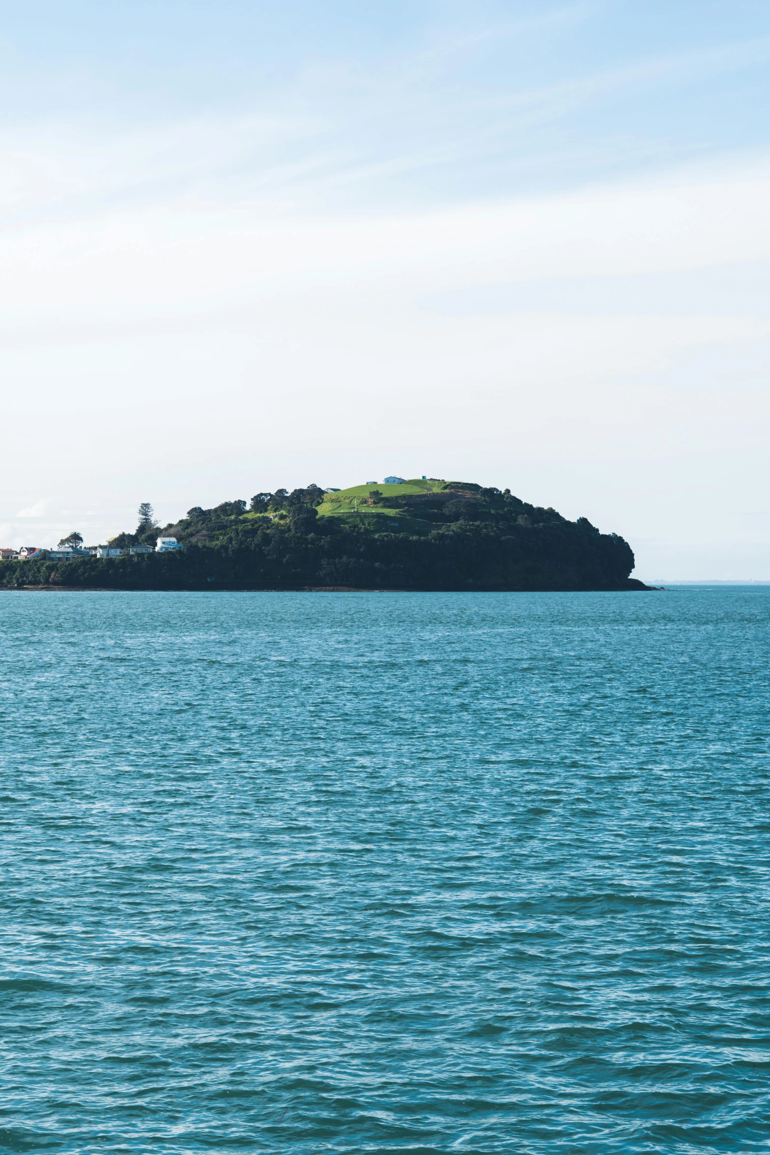 the water is very wide and has an island with trees