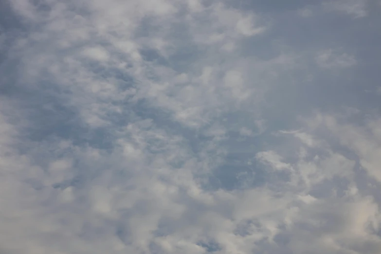 a plane in the sky with white clouds