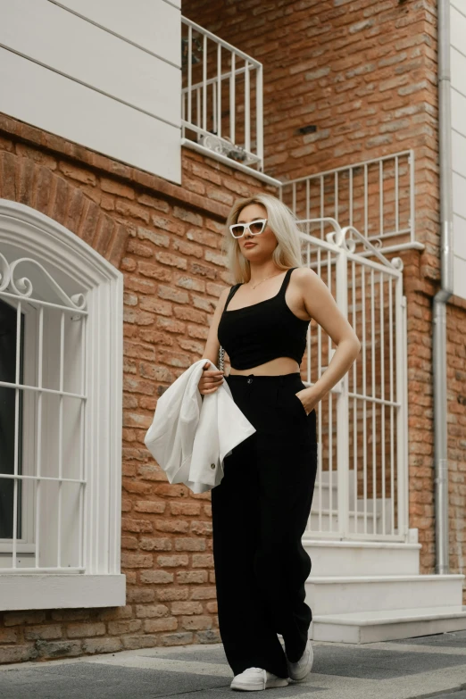 the woman is standing on a street and posing for the camera