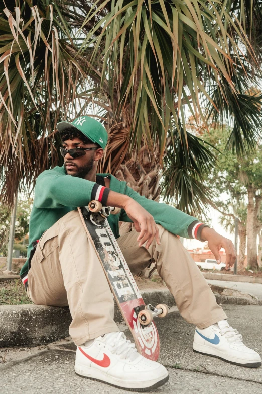 a man sitting down holding his skateboard