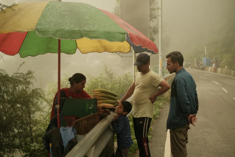 a group of people standing near an umbrella