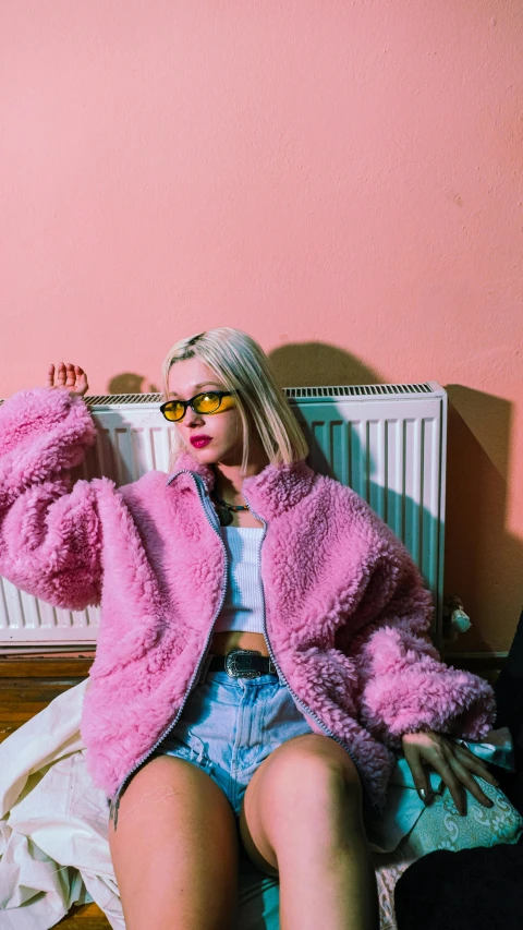 a woman with sunglasses on her head and a pink fuzzy coat