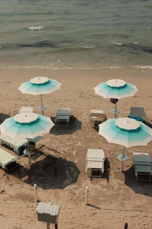 chairs and umbrellas in the sand on a beach