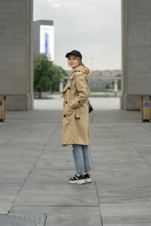 woman posing for picture on sidewalk in urban area