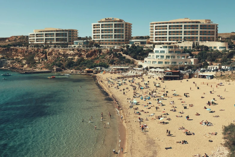 people are relaxing and sunbathing at the beach