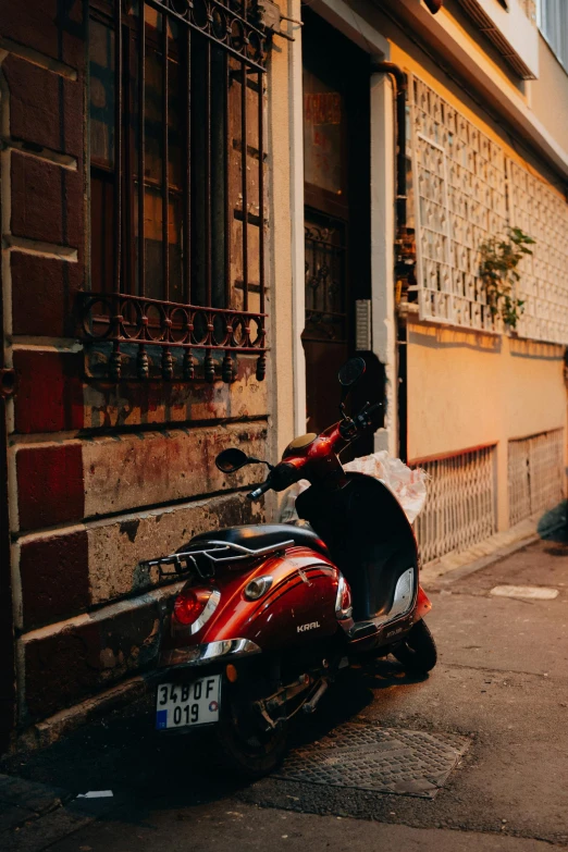 a red scooter sitting in front of an old building