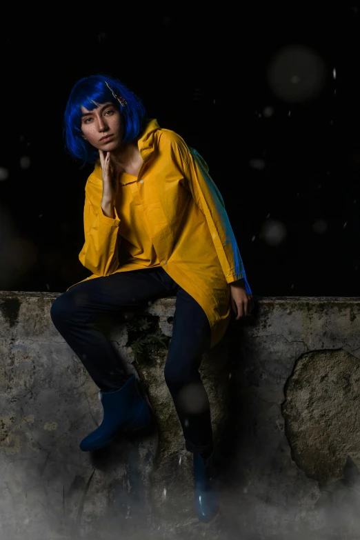 a woman is sitting on a wall in rain with her chin resting under her hand and looking directly at the camera