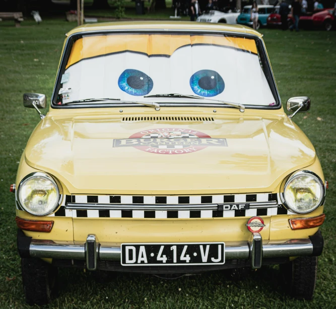 a car with eyes painted on the front in a park