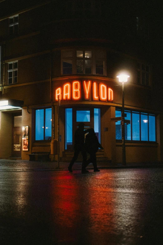 a large sign in front of a building lit up at night