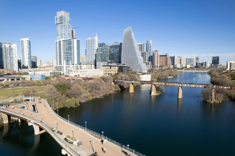 a bridge in the middle of a body of water near city buildings