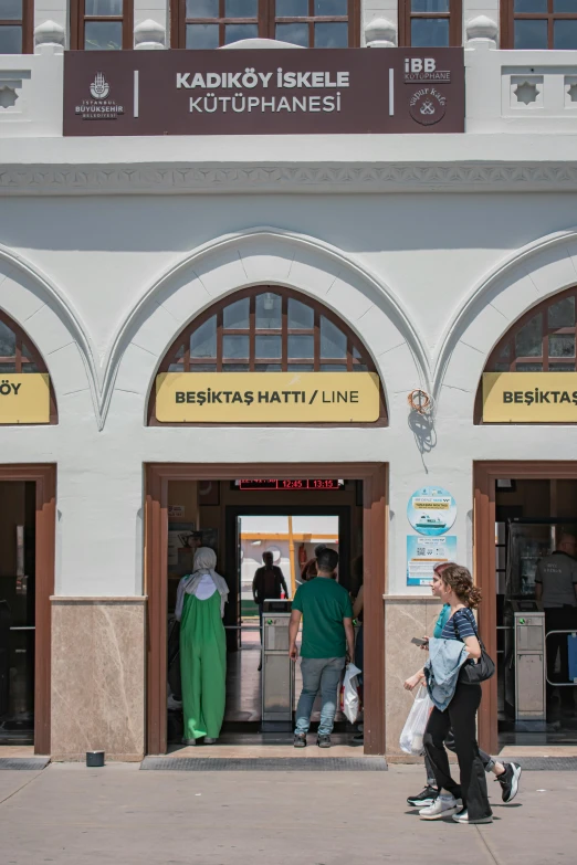 a boy and his mother standing outside the front entrance of a bank