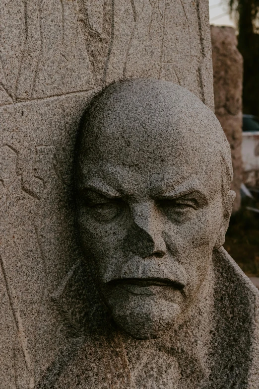 a face with a beard next to a stone wall