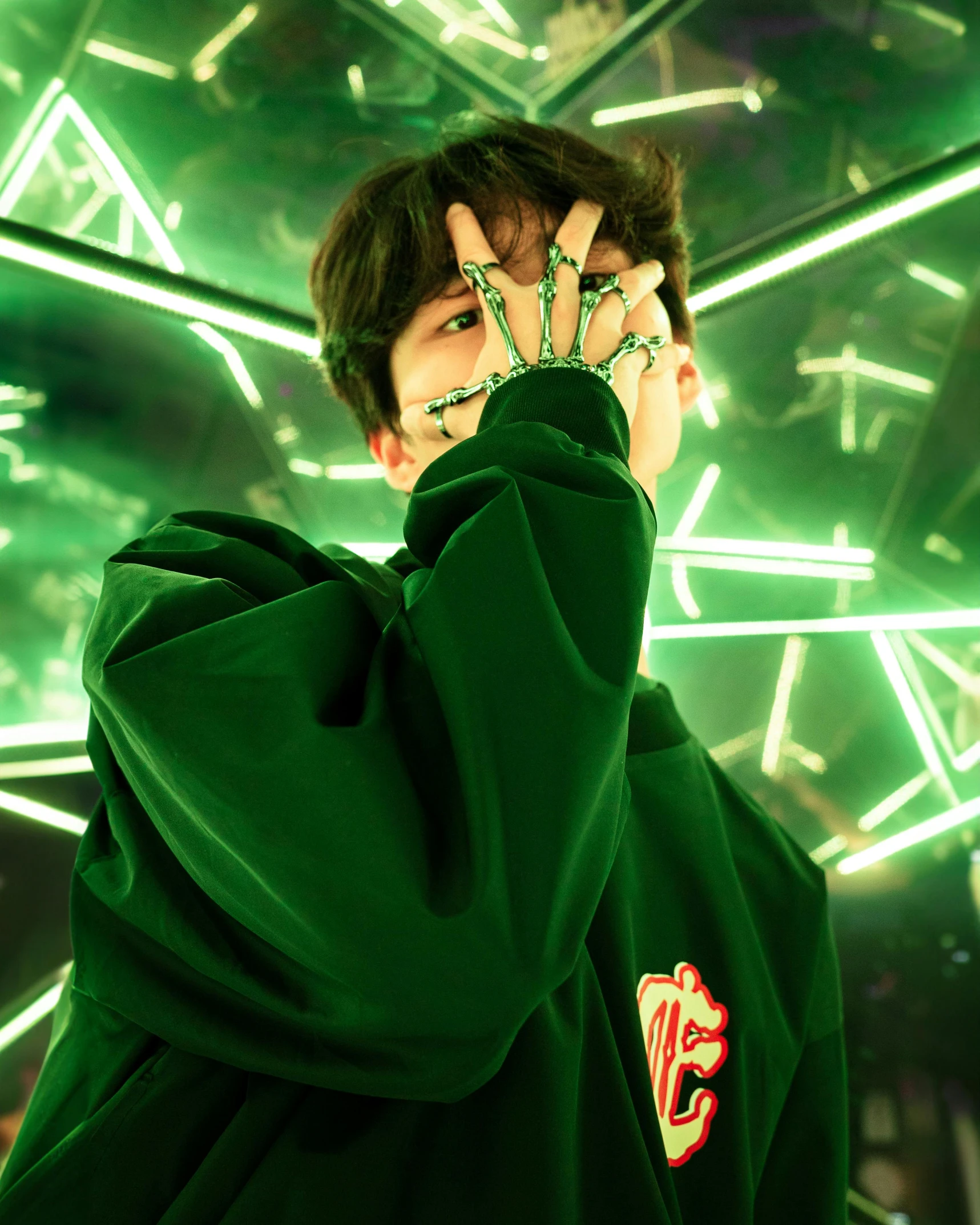 a young man wearing green with a hand printed ring