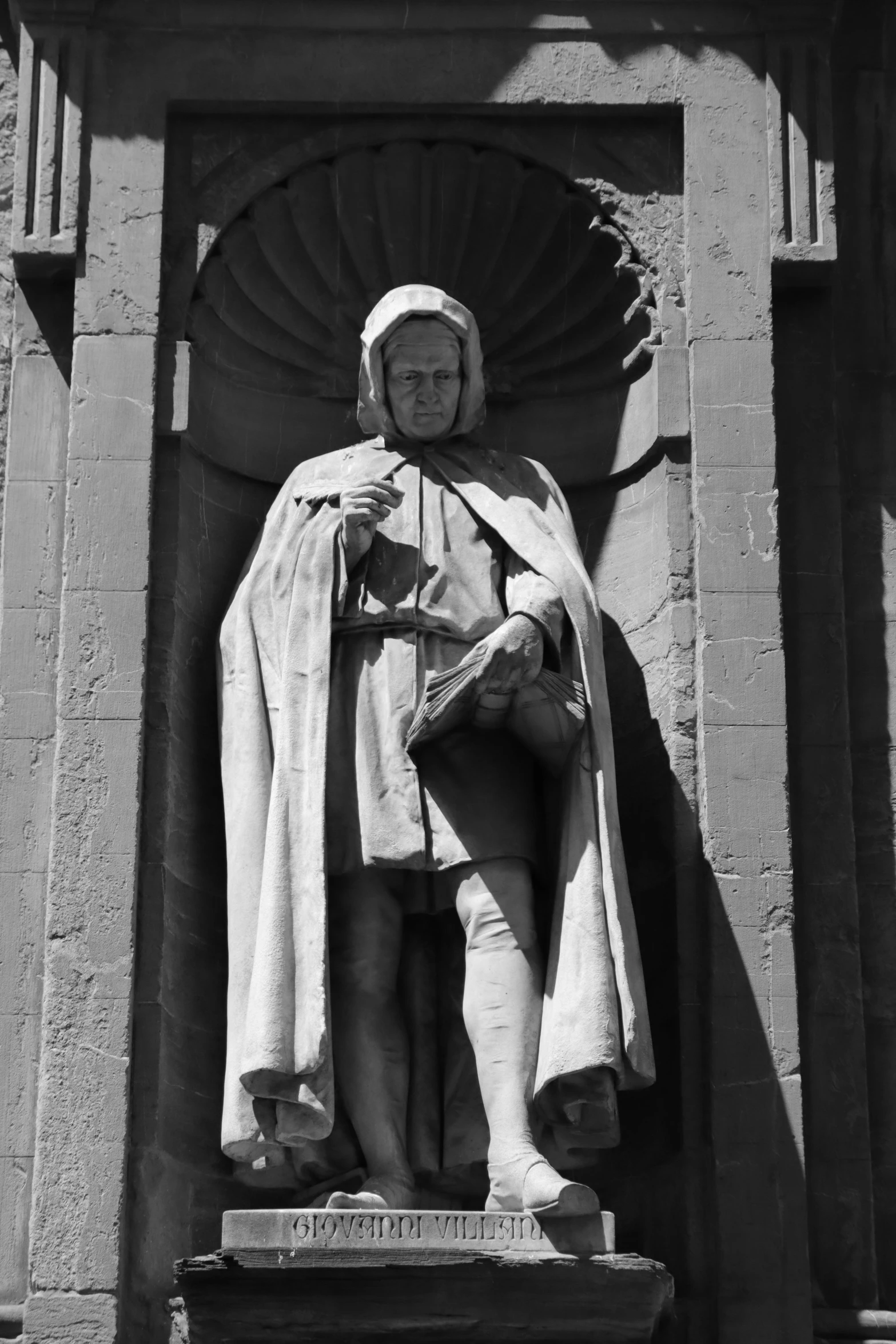 black and white pograph of statue with a coat