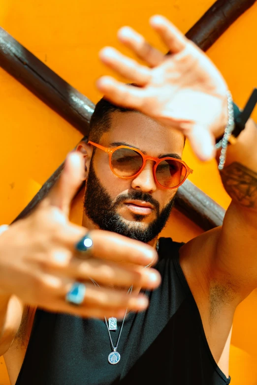 man wearing sunglasses making faces holding an unoned cross