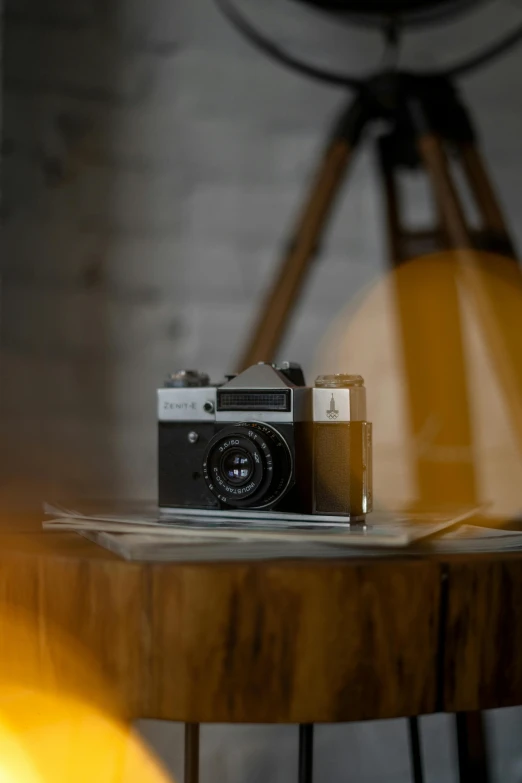 an old style camera and wooden table with a light in the background