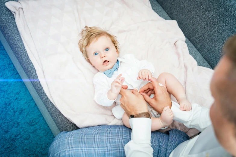 a baby sitting in a persons lap with his parent