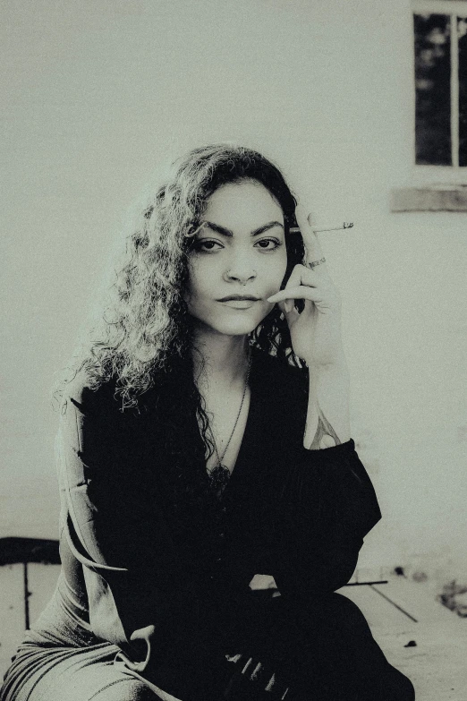 a woman sitting on the ground talking on her cell phone