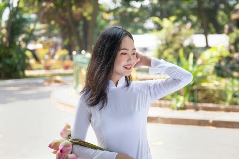 a young woman in white poses near flowers