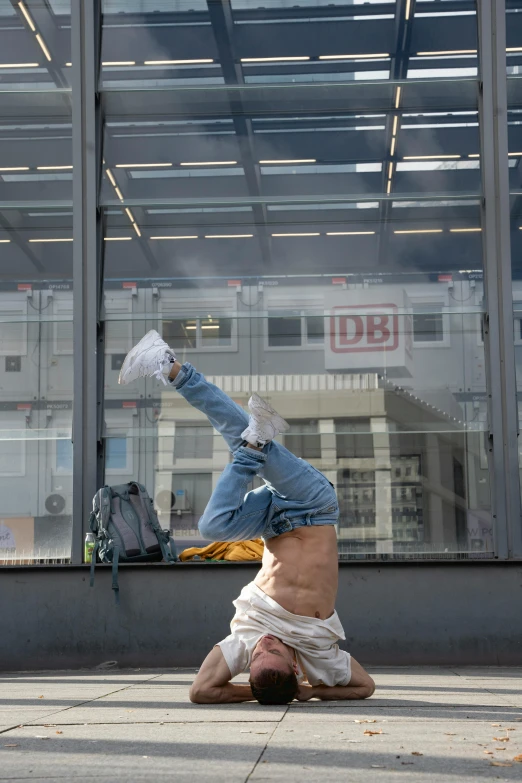 a man is performing a hand stand on a sidewalk