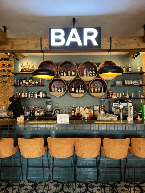 an empty bar with brown chairs and a brick wall