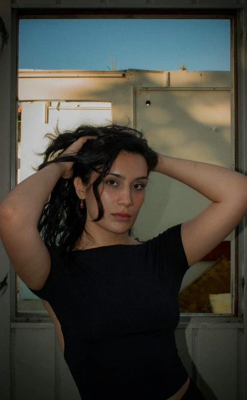 woman standing in front of a door with her hair blown back