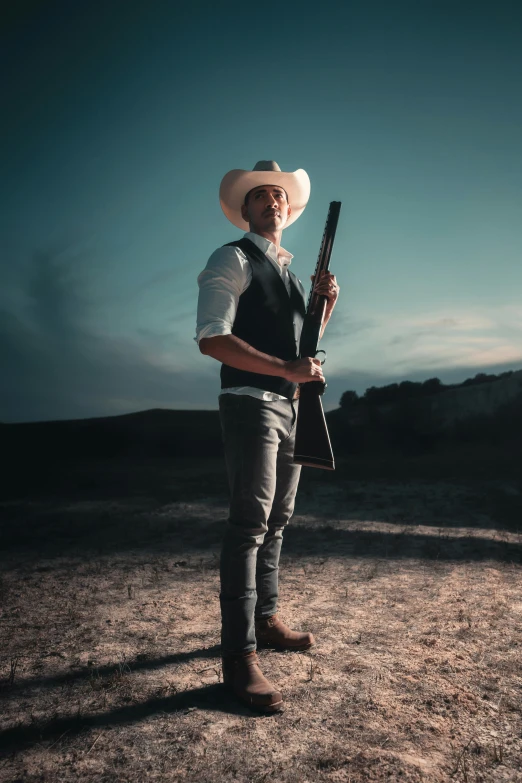 a man wearing a cowboy hat holding a gun