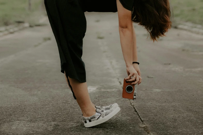 a woman bending down on her leg with a camera