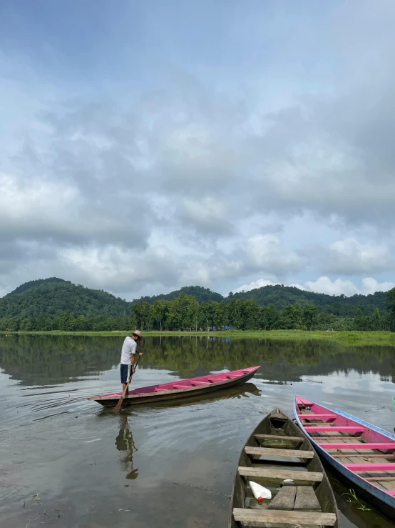 some canoes and people in the water near the shore