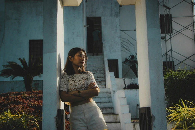 an indian woman standing in front of blue building