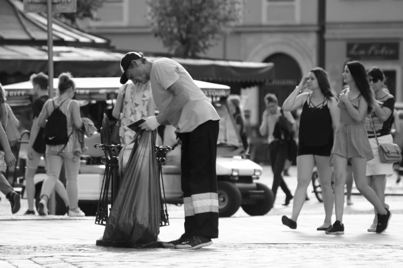 man standing on side of street next to parked car and woman holding flower pot