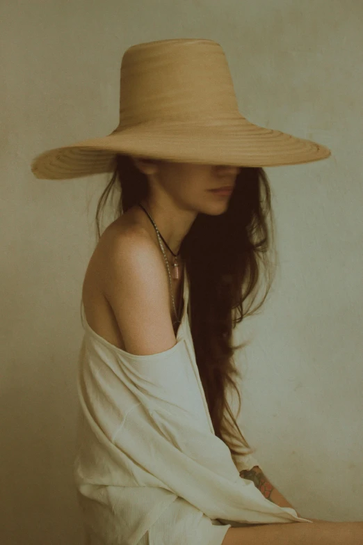 young woman in white blouse and wide brimmed straw hat