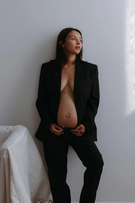 a pregnant woman poses for a po in a suit