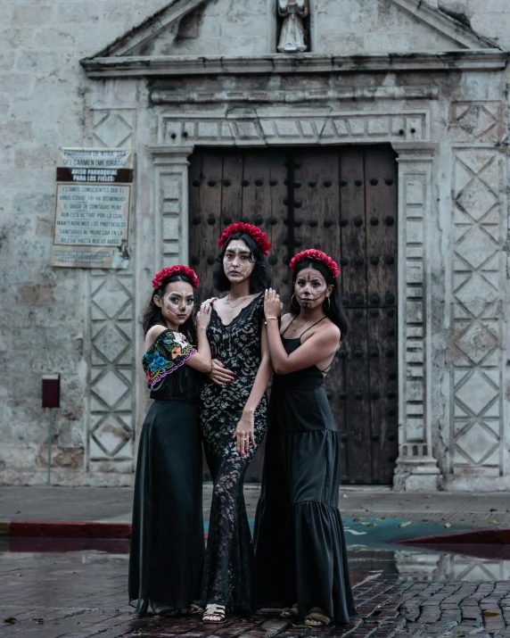 three women stand outside an old building and pose for a po