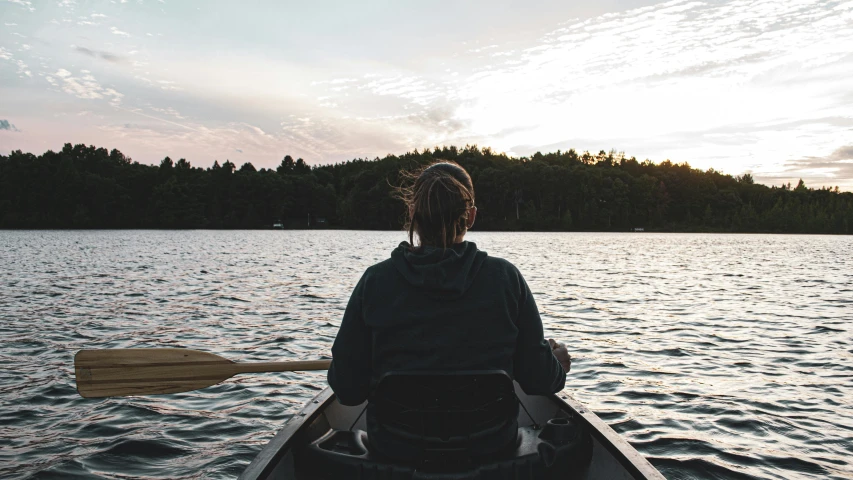 a person rowing in a canoe on water