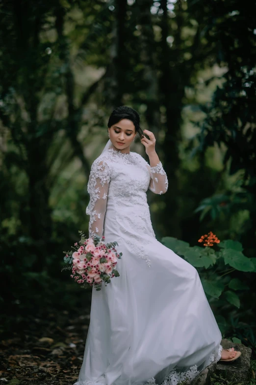 bride standing in the woods looking off to the side