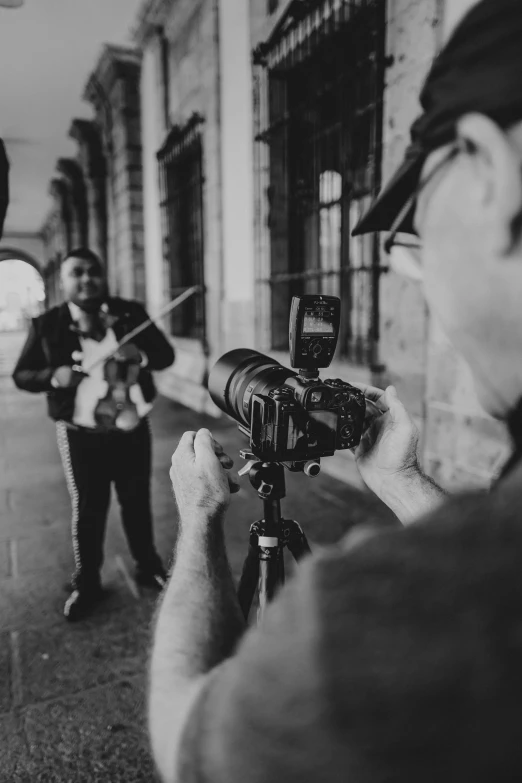 two people holding cameras in front of a building