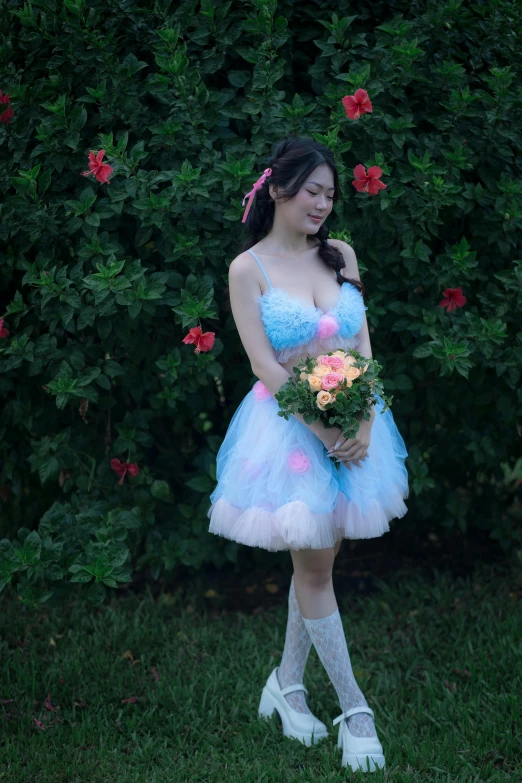 an attractive woman in a flower dress standing in front of shrubbery