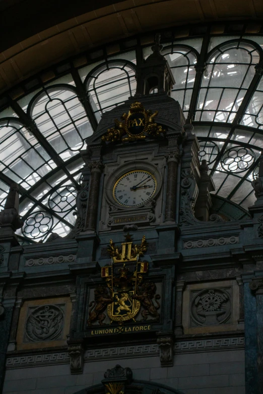 clock on the wall in front of windows and a domed ceiling