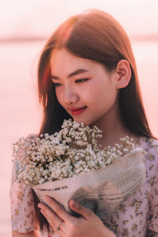 a young woman holding white flowers in front of her face