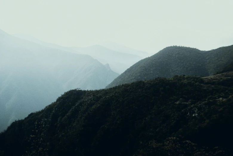 the tops of mountains are covered in mist