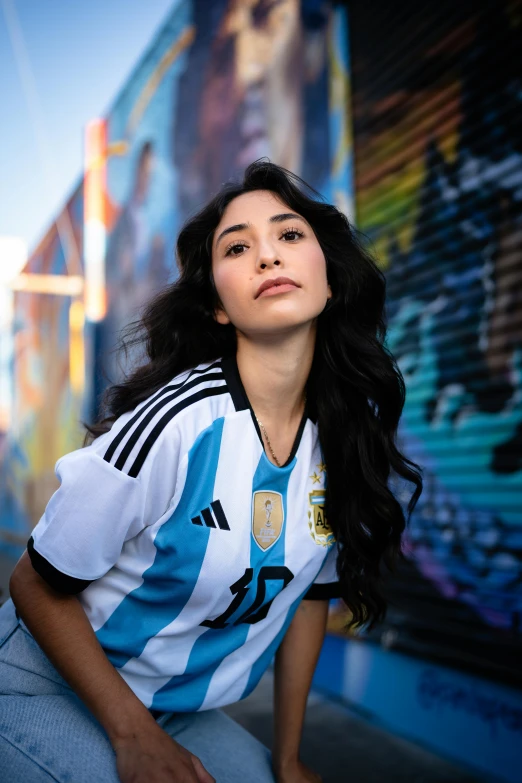 a beautiful woman sitting in front of a graffiti wall