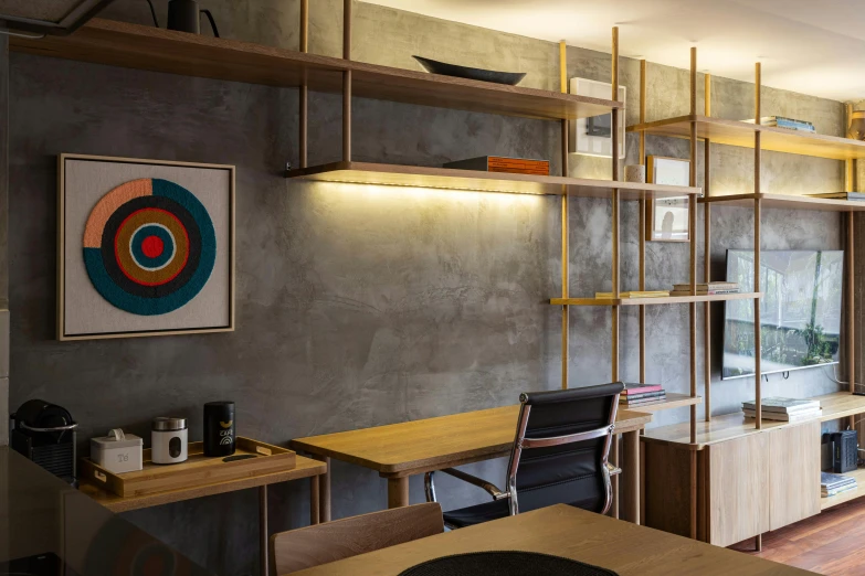 a room with shelves, a desk, chairs and a wall mounted bookcase