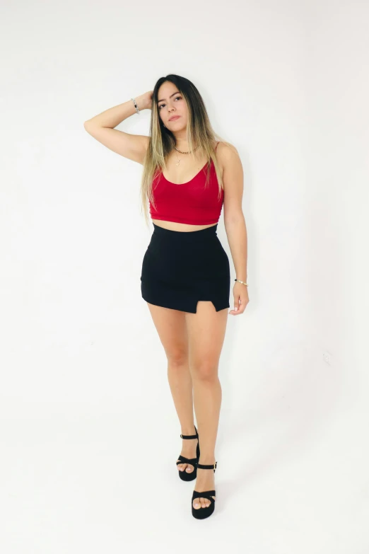 the model is wearing short black shorts and a red top