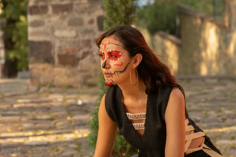 a woman is sitting with her face painted