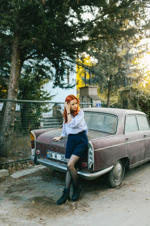 a woman that is sitting on the front of a car