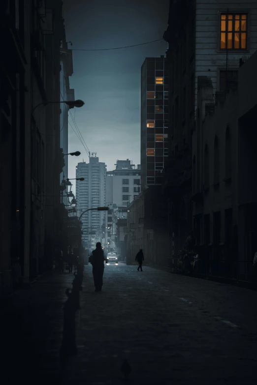 two people walking down a street at night