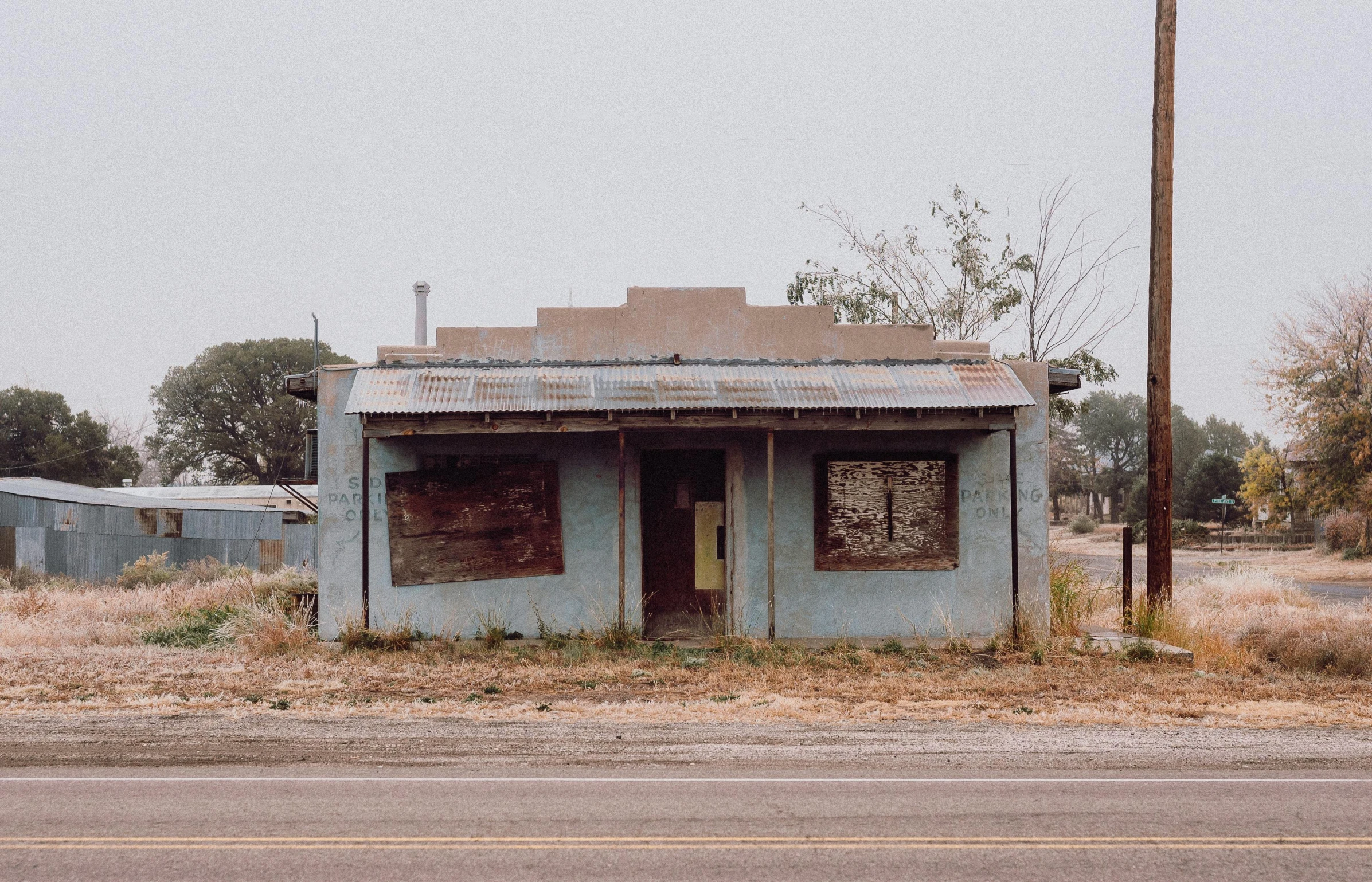 a small building with a window and peeling paint