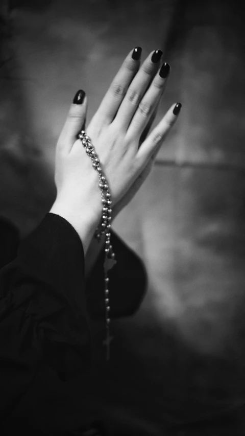 black and white pograph of hands with beads