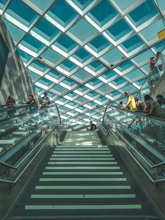 some escalators going down a stairway that leads up to a ceiling